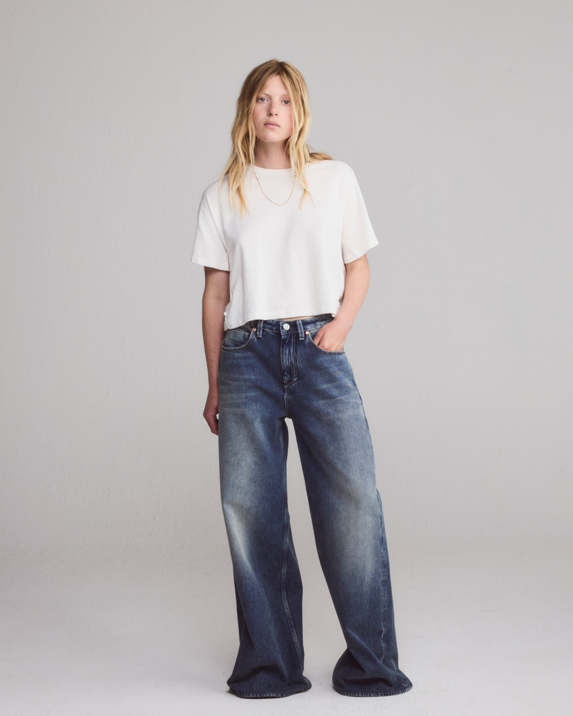 White boxy cropped T-shirt ending at the waistband of wide jeans